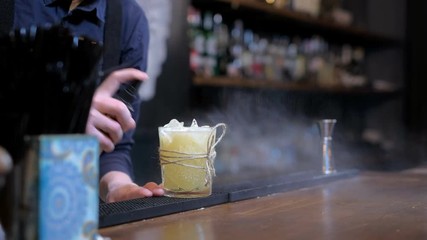 Expert barman is making cocktail at bar