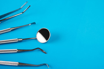 Set of Dentist's medical equipment tools. Stainless steel dental equipment on blue background with copy space. 