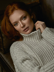 Portrait of a beautiful red-haired girl on the couch
