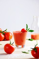 Fresh tomato juice in the glass on the white background