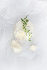 fresh cream cheese wit oregano on white paper and white wood table can be used as background