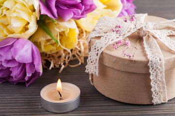 Purple yellow tulip flower, lit candle
