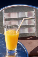 orange juice glass with a straw