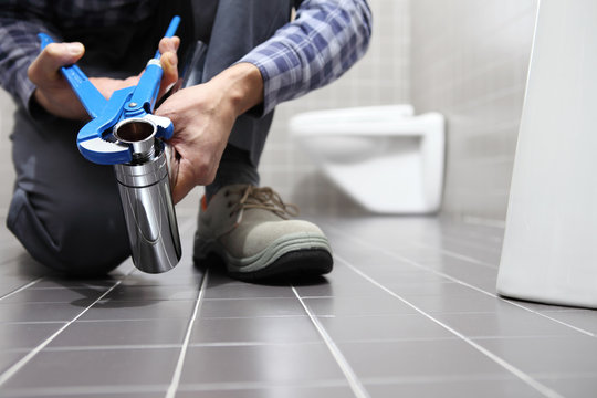 hands plumber at work in a bathroom, plumbing repair service, assemble and install concept