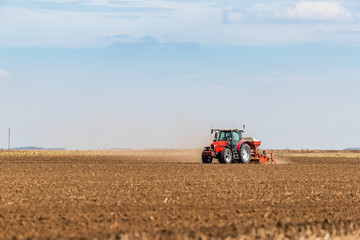 Farmer seeding, sowing crops at field. Sowing is the process of planting seeds in the ground as part of the early spring time agricultural activities.