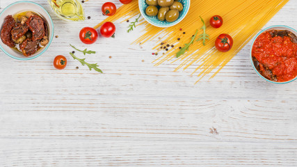 Ingredients for preparation pasta spaghetti - tomato, olive oil, spices, herbs, green olives, tomato sauce