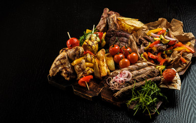 Assorted delicious grilled meat with vegetable. Mixed grilled bbq meat with vegetables. Mixed grilled meat on wooden platter