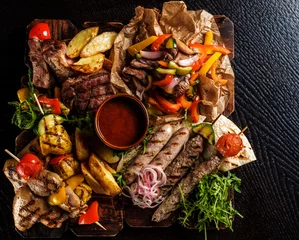 Photo sur Plexiglas Viande Assorted delicious grilled meat with vegetable. Mixed grilled bbq meat with vegetables. Mixed grilled meat on wooden platter