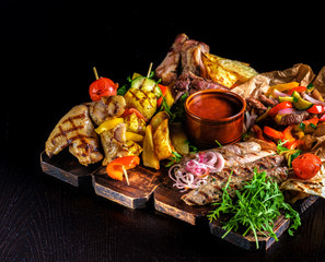 Assorted delicious grilled meat with vegetable. Mixed grilled bbq meat with vegetables. Mixed grilled meat on wooden platter
