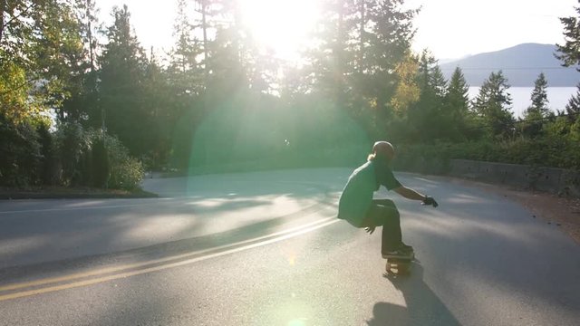 A clip of skateboarders sliding downhill on longboards.