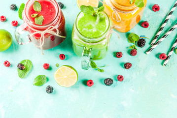 Healthy fresh fruit and veggie smoothies with ingredients on light blue concrete table, copy space 