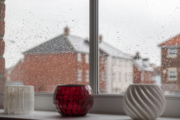 Rainy day depression. Selective focus on raindrops on modern house window glass pane. Time passing slowly.