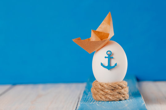 Easter egg with marine decor on a wooden background