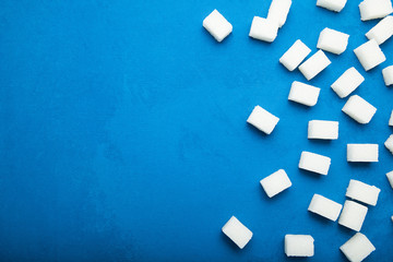 Sugar refined cubes on a blue background. Copy space.