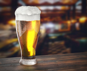 glass of fresh beer on the wooden table in a brewery