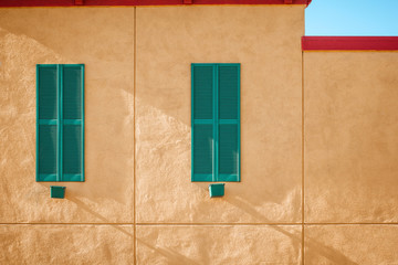 Bright building facade with shutters against the sky