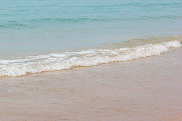 Soft wave of the blue ocean on the seashore of Thailand, copy space on the sand.