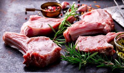 Meat Raw Fresh Mutton on the bone Spices Chesno and Rosemary on a black background