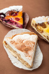 Selection of sweet slices on a brown background, selective focus.