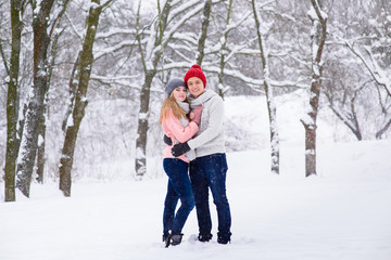 Young couple in hugs in snow forest