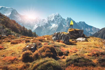 Photo sur Plexiglas Manaslu Homme debout sur la pierre et regardant sur les incroyables montagnes de l& 39 Himalaya au coucher du soleil. Paysage avec voyageur, hauts rochers aux sommets enneigés, plantes, forêt en automne au Népal. Mode de vie, voyage. Randonnée