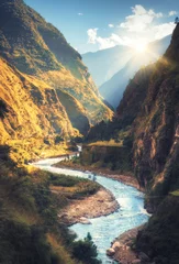 Fototapete Hellblau Bunte Landschaft mit hohen Himalaya-Bergen, schönem geschwungenem Fluss, grünem Wald, blauer Himmel mit Wolken und gelbem Sonnenlicht bei Sonnenuntergang im Herbst in Nepal. Bergtal. Reisen im Himalaya
