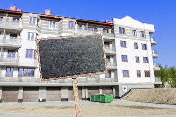 Blackboard label and a apartment building in the background