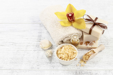 Spa cosmetics and flowers on wooden table.