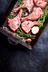 Meat Raw Fresh Mutton on the bone Spices Chesno and Rosemary on a black background pan Top View Copy space for Text