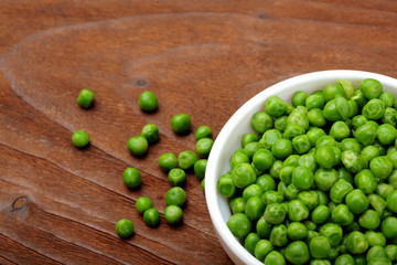 Green peas.In white bowl.On wooden background, table.Top view .Copy space
