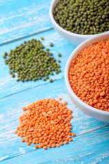 Red lentils and green bean or mung bean in bowl on a blue wooden table.Copy space.Clsoeup .Selective focus