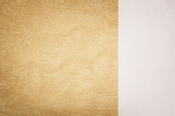 Top view of sandy beach with towel frame. Background with copy space and visible sand texture. Border composition made of towel