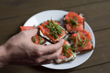 sandwich with fish on wooden background