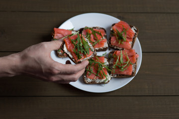 sandwich with fish on wooden background
