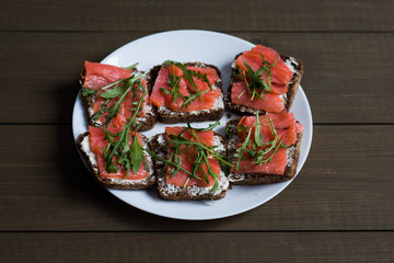 sandwich with fish on wooden background