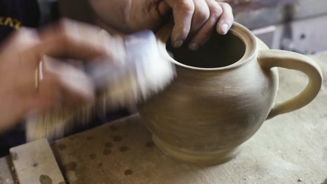 polishing the finished clay kettle