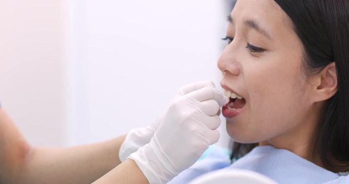 Dentist showing the use of dental floss in clinic