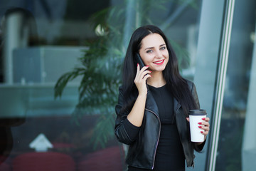 Fototapeta premium Businesswoman Using Digital Smartphone and Drink Coffee Near Beside Office Building