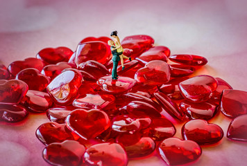 Miniature Couple Standing On Hearts Hugging