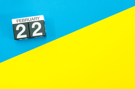 February 22nd. Day 22 of february month, calendar on blue and yellow background flat lay, top view. Winter time. Empty space for text