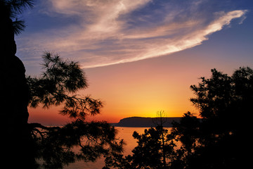 Sunrise over the sea in the mountains at the summer. Mountain view in the evening ocean.