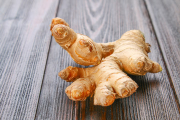Spicy root of ginger on a wooden table.