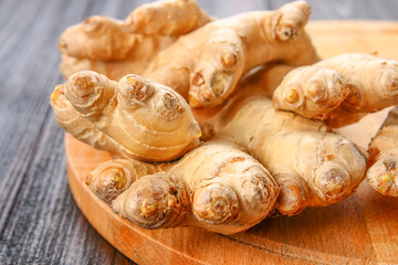 Spicy root of ginger on a wooden table.