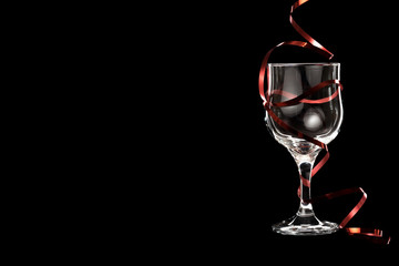 Fototapeta na wymiar An empty glass of white wine with a red ribbon.