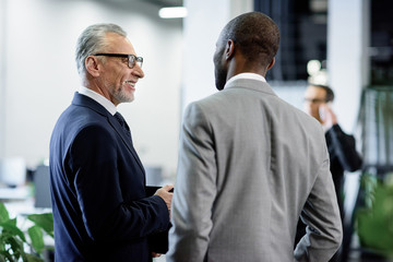 selective focus of multicultural businessmen having conversation in office