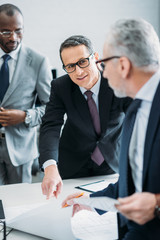 selective focus of multicultural businessman discussing new strategy in office