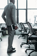 Fototapeta premium partial view of african american businessman with tablet in hand in office