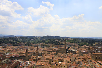 Fototapeta na wymiar City panorama, aerila view, Florence, Tuscany, Italy; roofs, buildings, towers and hilly suburbs in the background.