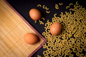 pasta with eggs on black background