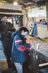 10-year-old boy in a carpenter's workshop learns how to do small jobs